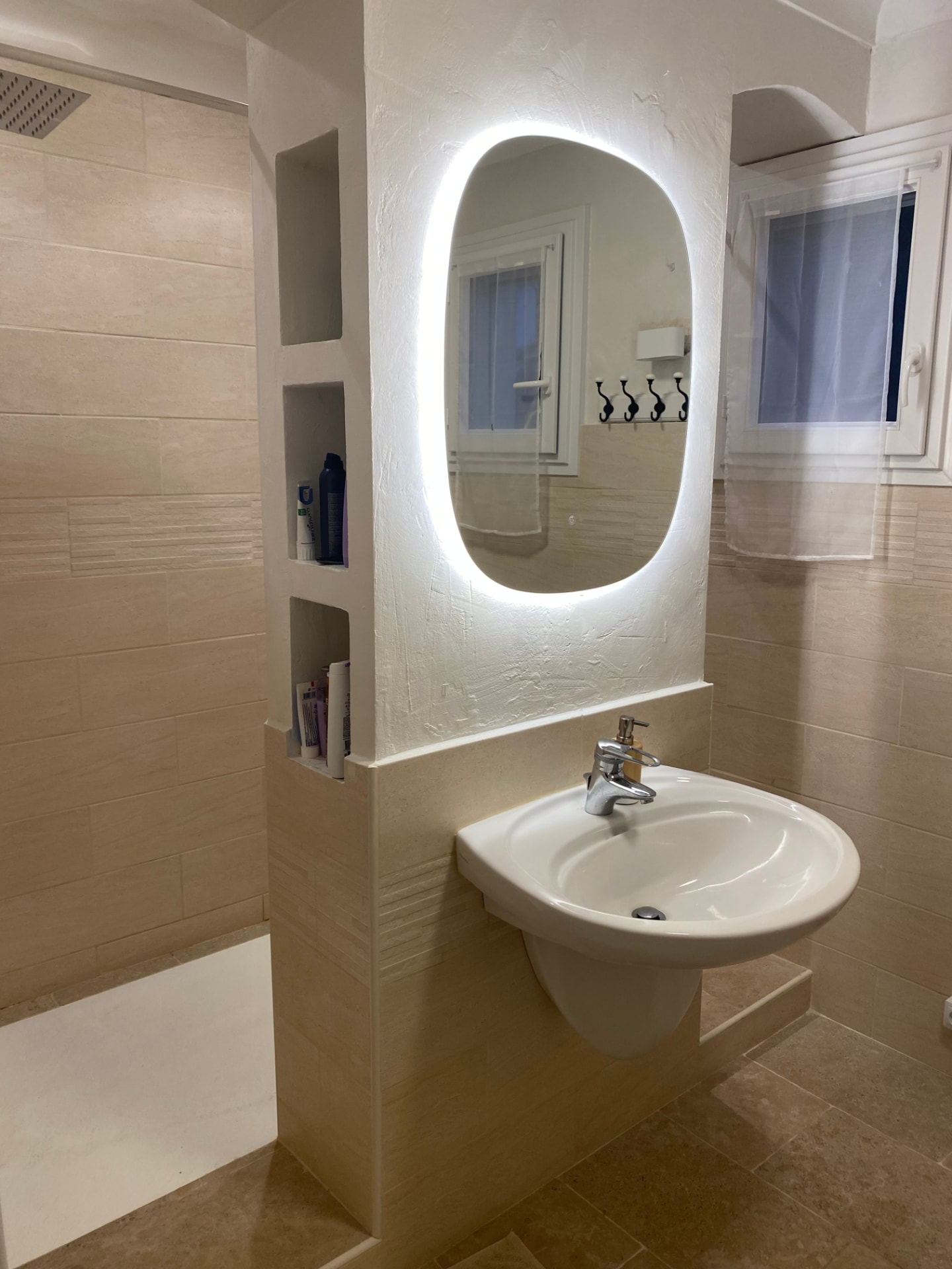 Modern bathroom with a walk-in shower and backlit mirror