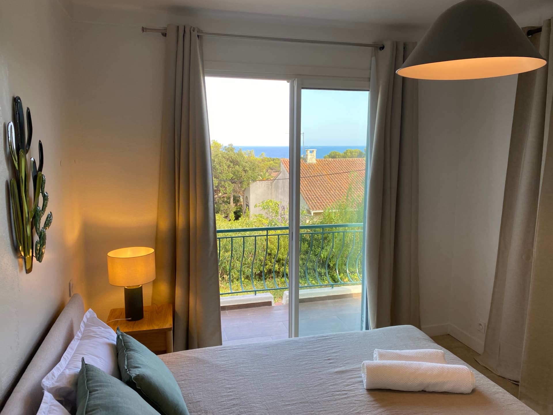 Green bedroom with a sea view through the window