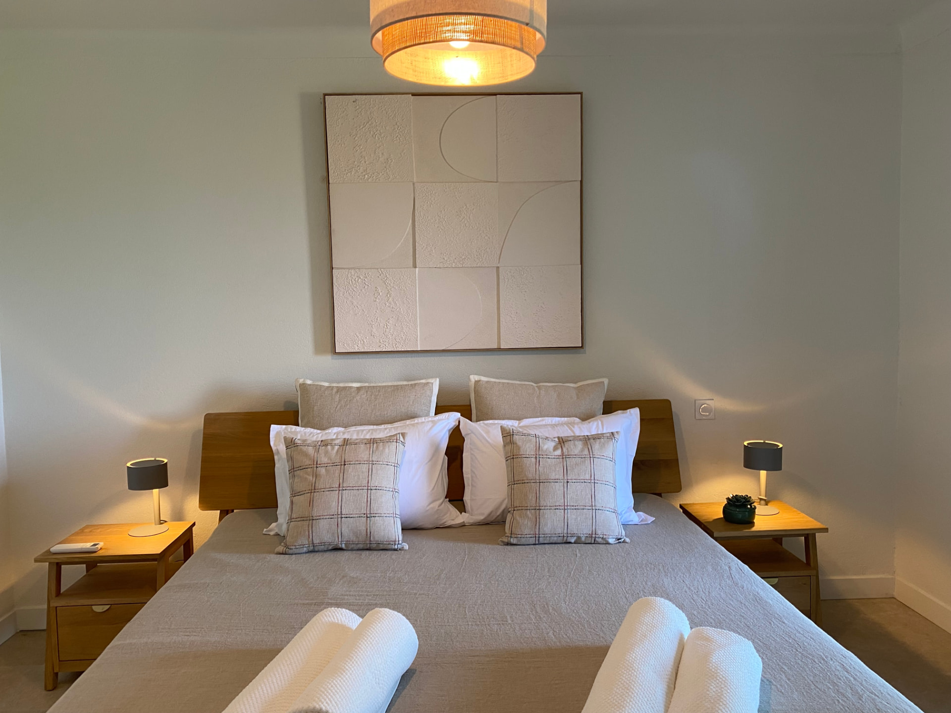 Close-up of the double bed in the beige bedroom with linen bedding