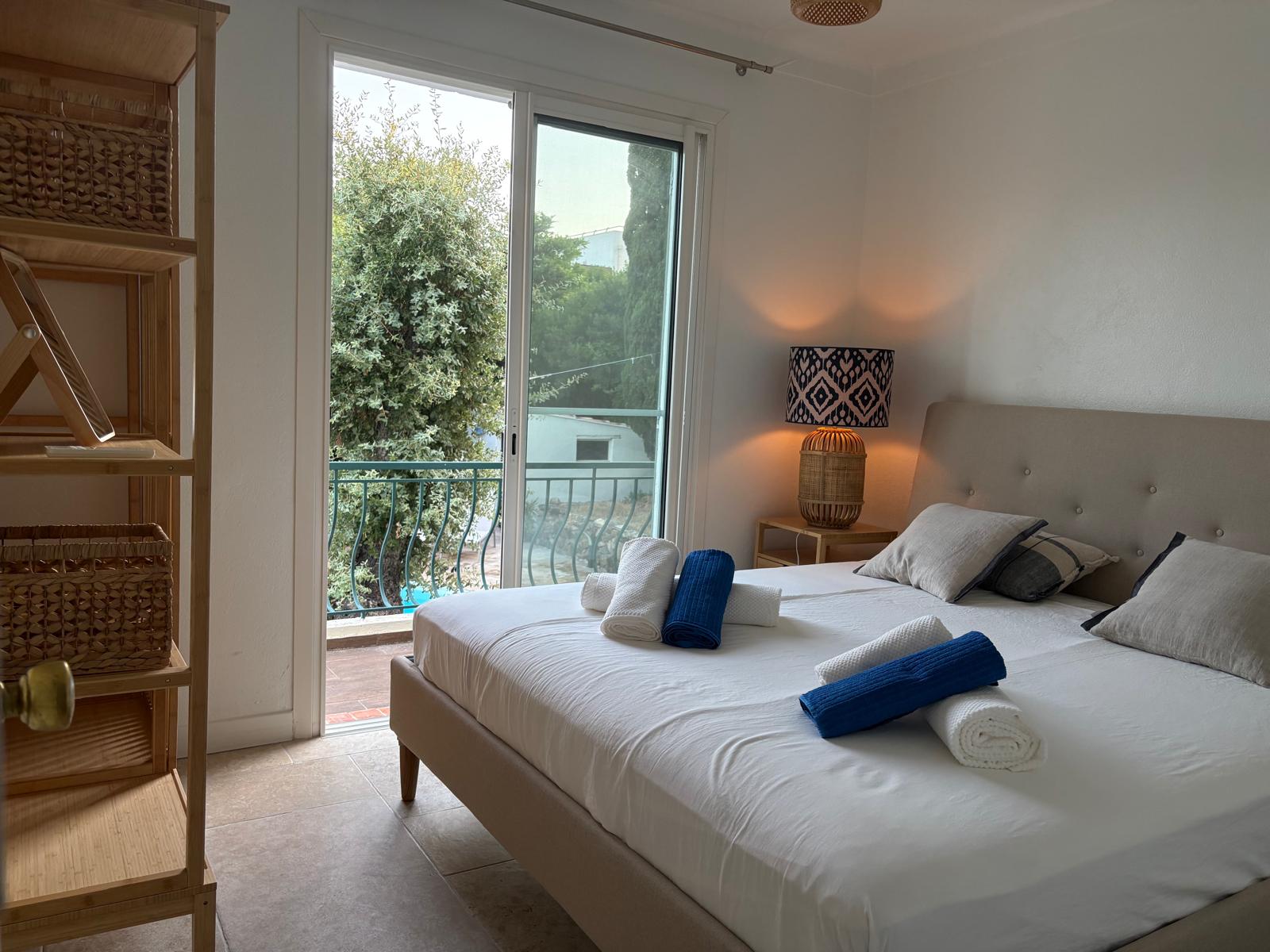 Blue bedroom with a balcony overlooking the garden