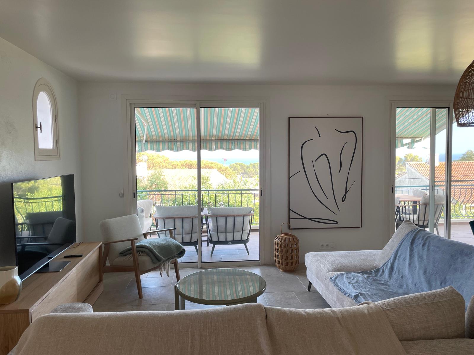 Living room with comfortable seating and doors out to the shaded terrace