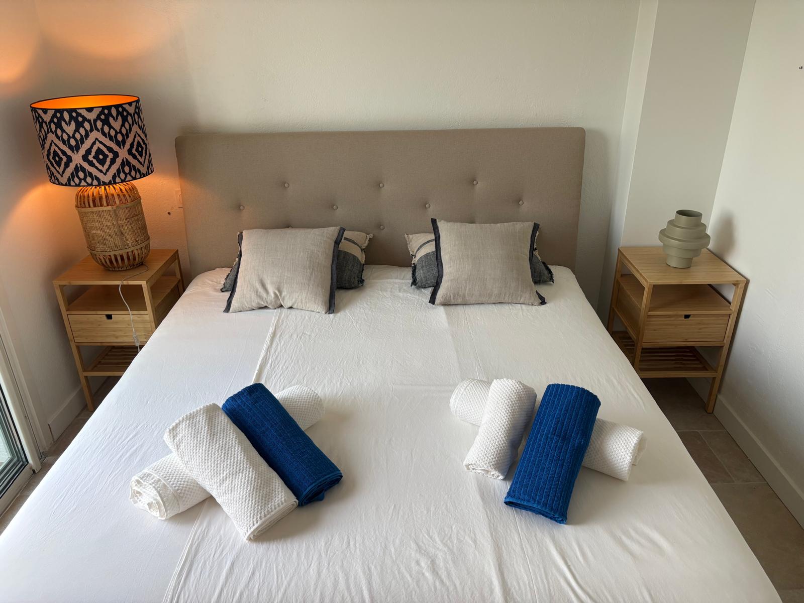 Double bed in the blue bedroom with fresh towels laid out