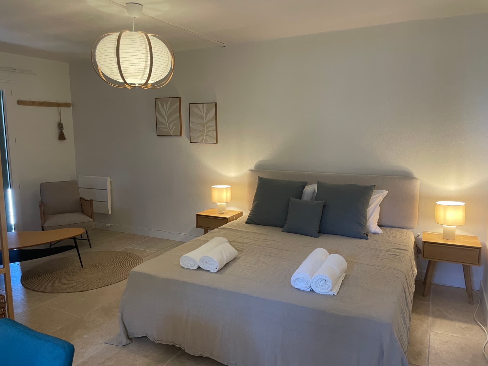 Bed in the separate studio with grey pillows and soft lighting